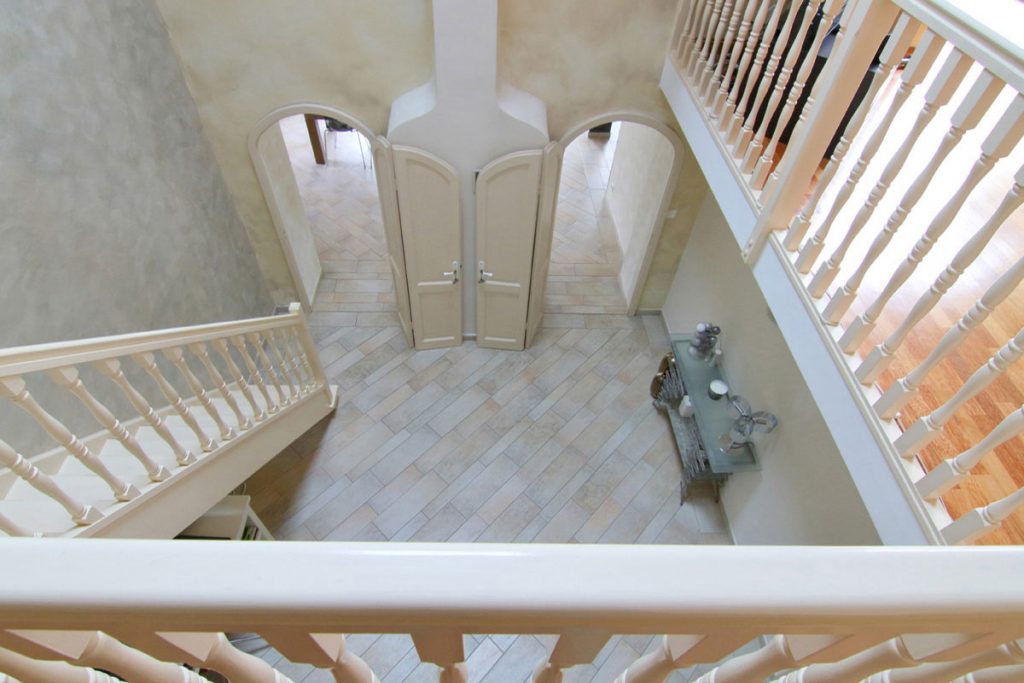 Photographie immobilière vue plongeante entrée cage d'escalier maison Kuntzig
